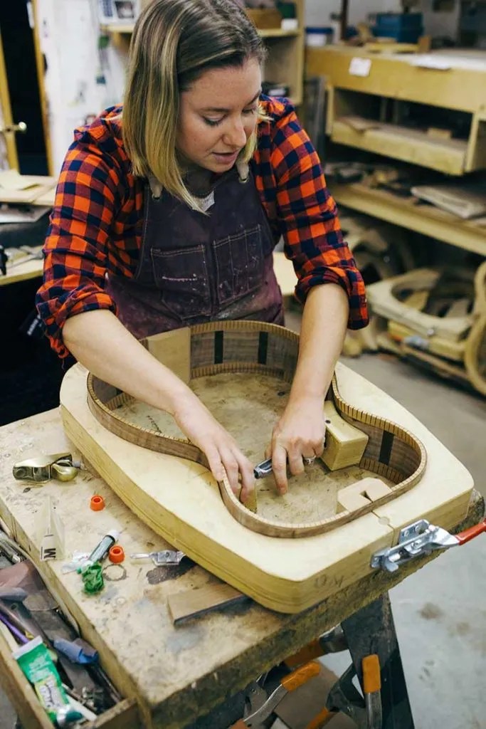 Luthier Jayne Henderson working on the inside of an acoustic guitar